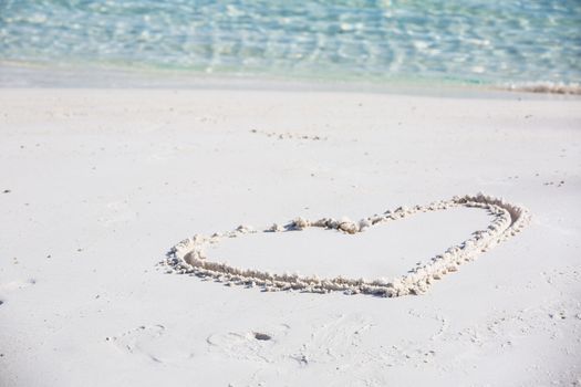 drawing heart symbol on the beach show romantic feeling