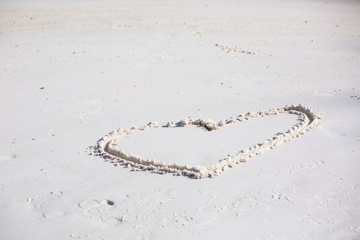 drawing heart symbol on the beach show romantic feeling