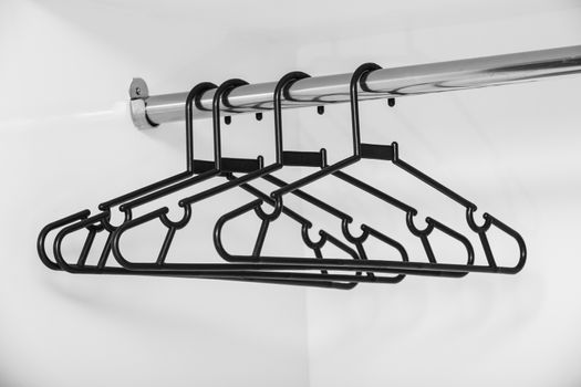 black plastic coat hanger on bar