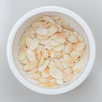 close up of sliced almond in white bowl