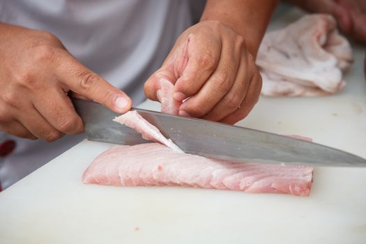 cutting tuna on a white table