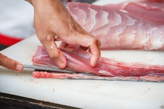 cutting tuna on a white table