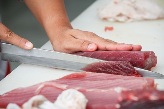 cutting tuna on a white table