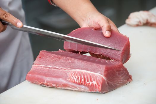 cutting tuna on a white table