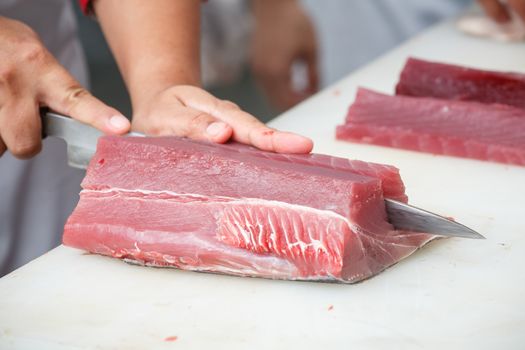 cutting tuna on a white table