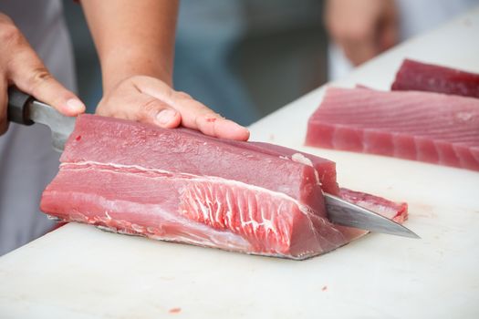 cutting tuna on a white table