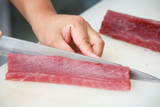 cutting tuna on a white table