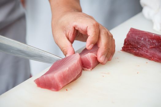 cutting tuna on a white table