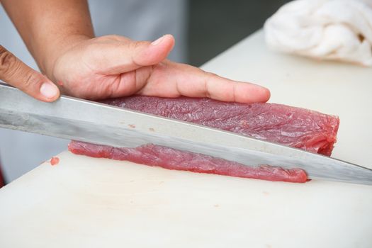 cutting tuna on a white table