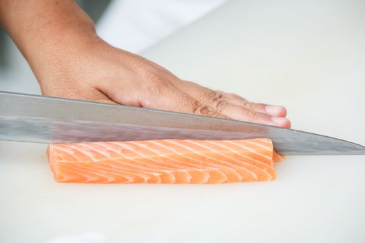 salmon is cutting on a white table