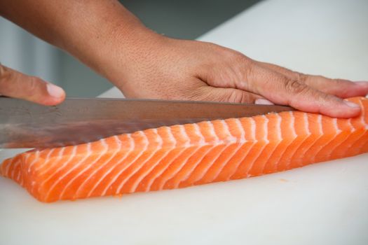 salmon is cutting on a white table