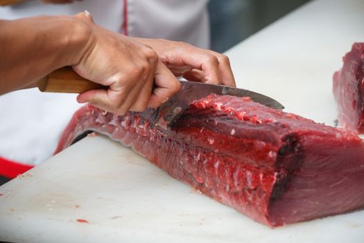 cutting tuna on a white table