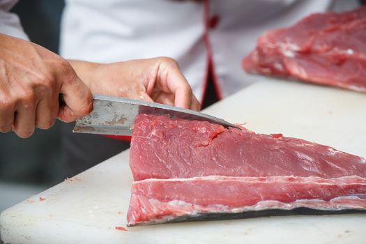 cutting tuna on a white table