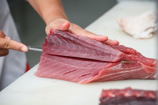 cutting tuna on a white table