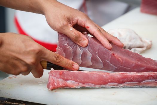 cutting tuna on a white table