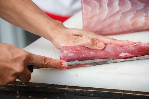 cutting tuna on a white table