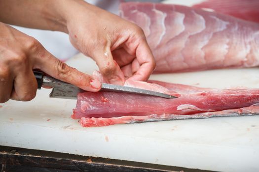 cutting tuna on a white table