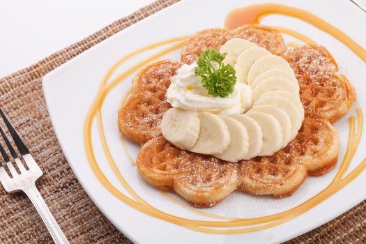 Banana waffle topping with maple syrup and whip cream