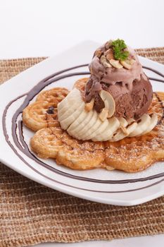 Banana waffle serve with chocolate ice cream topping with cashew nut