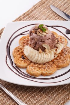 Banana waffle serve with chocolate ice cream topping with cashew nut