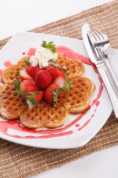 waffle topping with strawberry and decoration with strawberry sauce