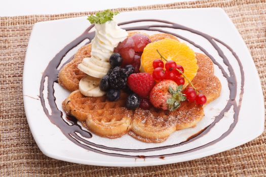 waffle with fresh fruit topping with maple syrup