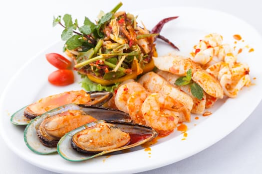 seafood with spicy salad on white plate