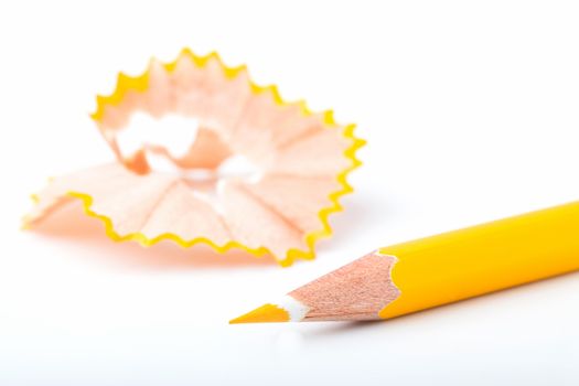 tip point of yellow pencils and shavings from sharpening on white background