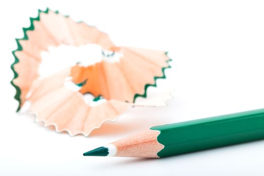 tip point of green pencils and shavings from sharpening on white background