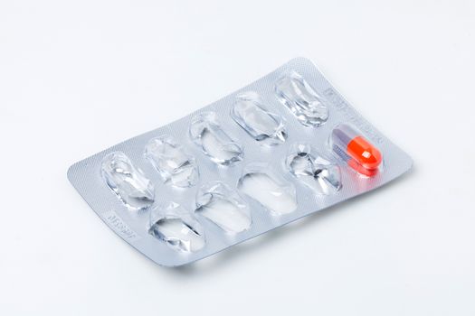 a last capsule of drug in package on white background