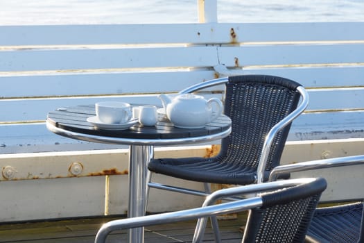 Empty Teapot and cups by the  sea