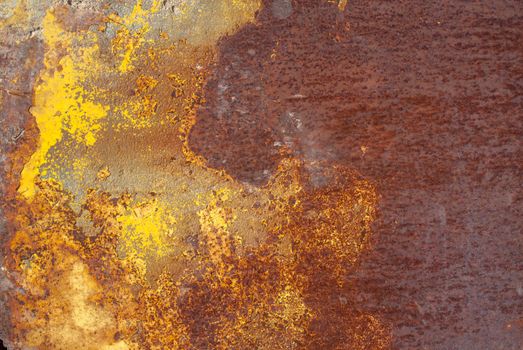 rusty iron surface covered with old chipped yellow color paint, which has long been influenced by different climatic conditions