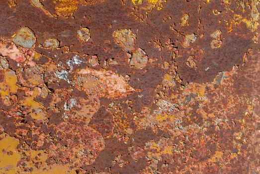 rusty iron surface covered with old chipped yellow color paint, which has long been influenced by different climatic conditions