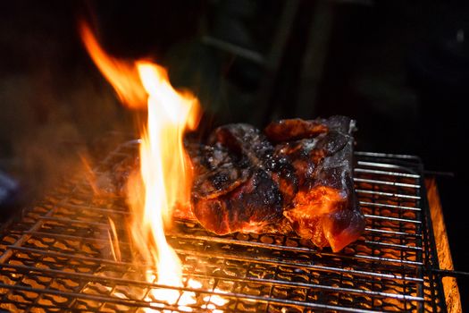 Beef on barbecue stove with flame.