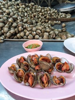 Boiled cockle on plate with spicy sauce.