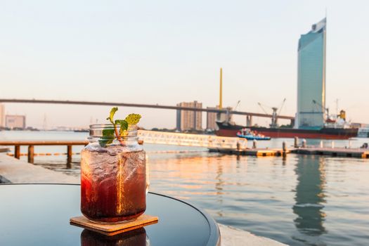 Blueberry soda with blurred Chaophraya river in background.