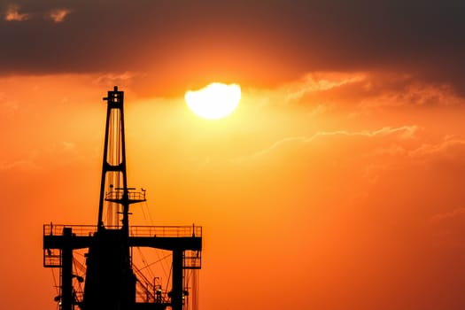 Silhouette picture of vessel with sunset in background.