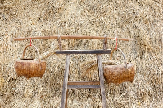 Rice in wooden basket on chair with hay in background.