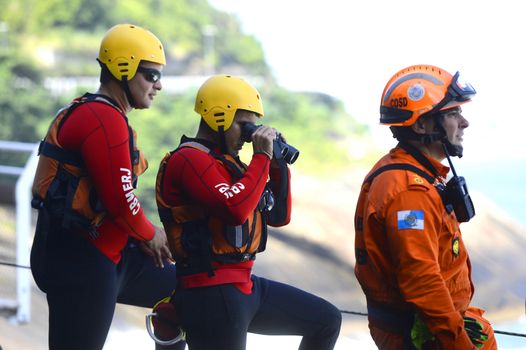 BRAZIL, Rio de Janeiro: Rescuers search the sea after a bike path inaugurated in January collapsed in Rio de Janeiro, on April 21, 2016. Two people were killed in the accident and one remains disappeared.