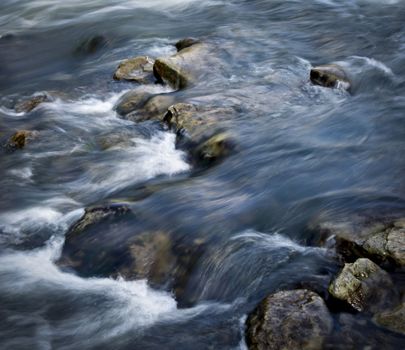 Seasonal background Spring river between stones