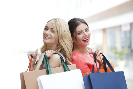 Young beautiful happy women with shopping bags in mall