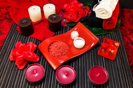 Still life of a coffee in red cup, chocolate, roses, candles and gift envelope