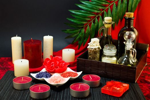 Still life of candle, tools for massage creams for skin care and bath salt.