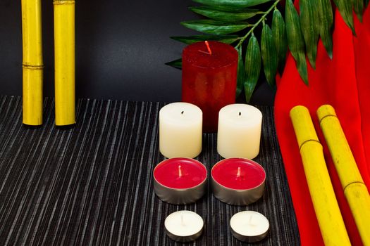 Template for a spa of the candles and bamboo on a black and red background