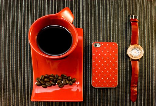 Red cup of coffee, watches with red strap, phone in red bumper