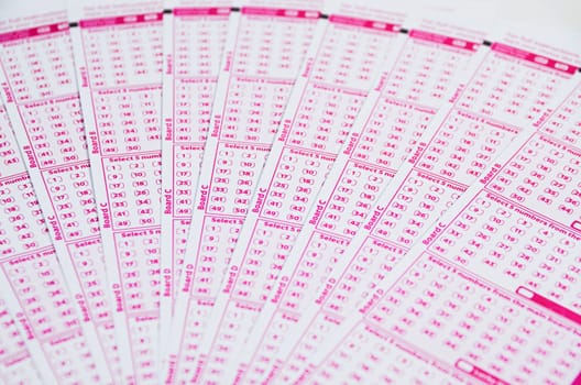 Blank lotto tickets scattered on white background

