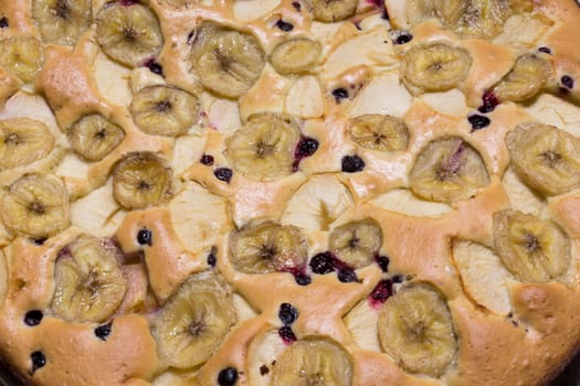 The photo depicts a cake with fruit and berries