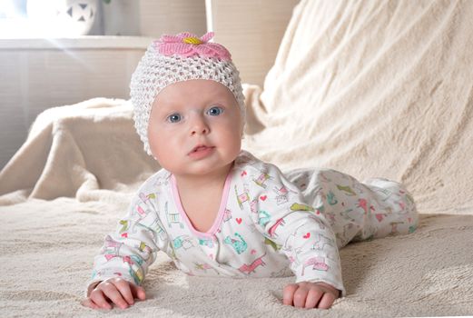 happy little cute baby girl in a dress and with flower smiling at home