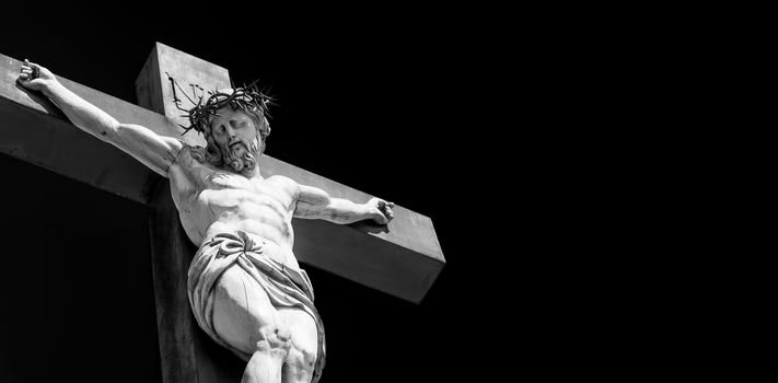 Crucifix made of marble with blue sky in background. France, Provence Region.