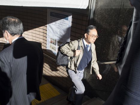 Tokyo, Japan - November 11, 2015: Busy underpass exit from train station in Tokyo. Typical peak hour morning rush human traffic in Tokyo.